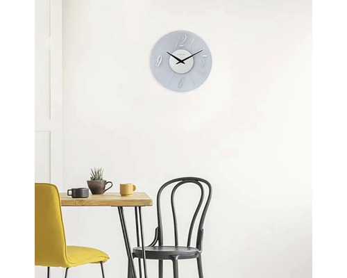 Scene met een wandklok boven een eettafel met stoelen