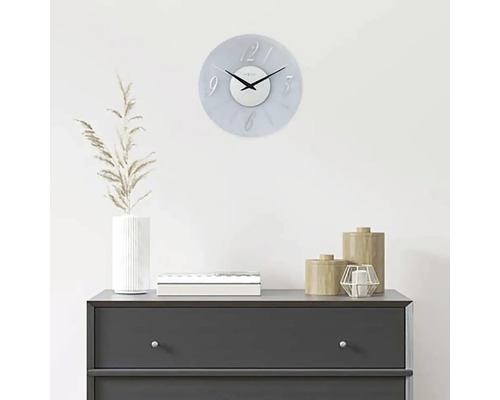 Decoratieve wandklok boven een dressoir met woonaccessoires