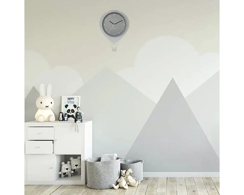 Kinderkamer met wandklok, opbergmeubels en speelgoedmanden voor een muur met bergmotief