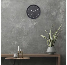 Wandklok in kamer met tafel, kaarsen en plant
