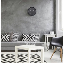 Woonkamer met bank, kussens, tafel, vloerkleed, stoel en wandklok