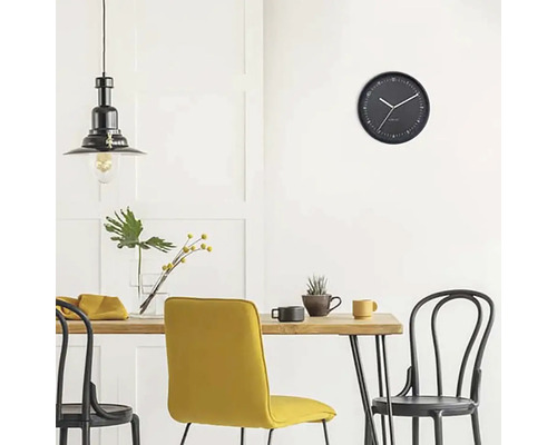 Eetkamer met eettafel, stoelen, hanglamp en een wandklok.