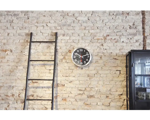 Scene met ladder, wandklok en kast voor een bakstenen muur