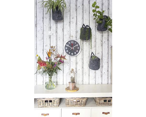 Wanddecoratie met planten, wandklok en commode met manden