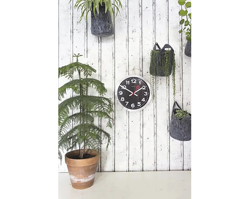 Wandklok met planten op een houten lambrisering