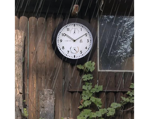 Wandklok met thermometer en hygrometer aan een houten muur in de regen