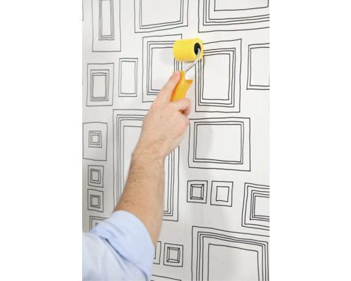 Behangen van een muur met een patroonbehang en een verfroller