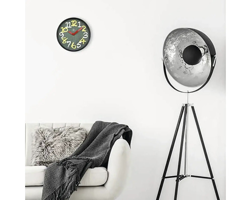 Woonkamer met bank, staande lamp en wandklok