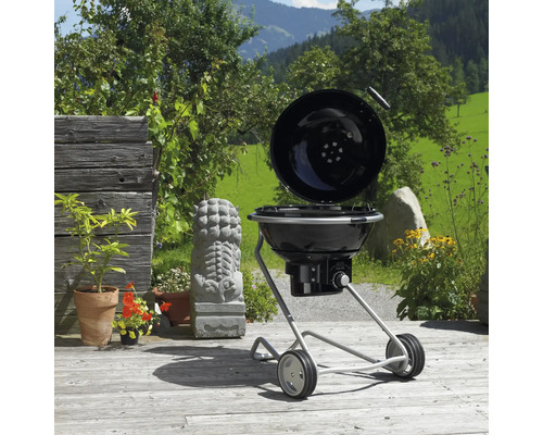 Bolgrill met open deksel op een terras in de buitenlucht