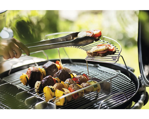 Grill met spiesen en grilltang in gebruik