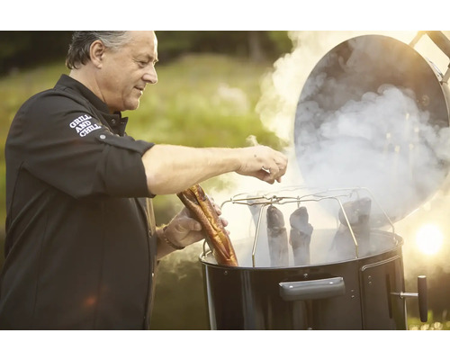 Man rookt vis in een rookoven buitenshuis