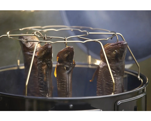 Gerookte vissen hangen in een ronde rookoven.