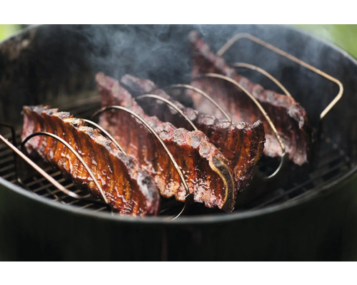 Spareribs in ribhouder op een barbecue
