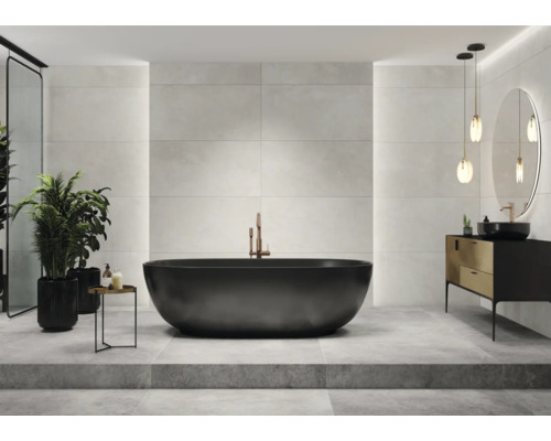 Badkamer met ligbad, wastafel, spiegel en tegels