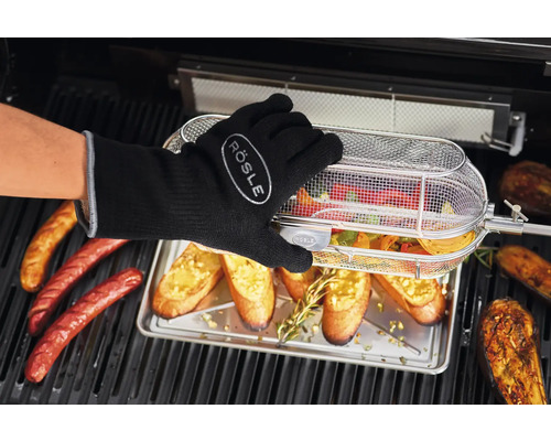 Groenten in de grillmand met worst, brood en aubergine op de grill met handschoen