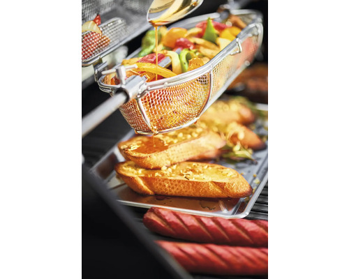 Groenten in een frituurmand boven geroosterd brood en worstjes