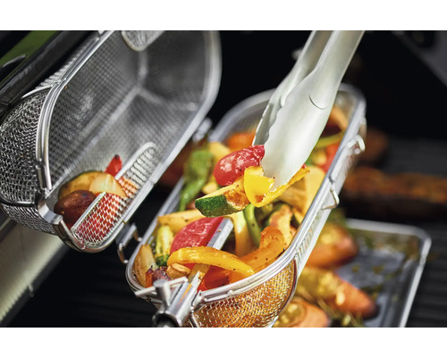 Groenten in een grillmand met een grilltang