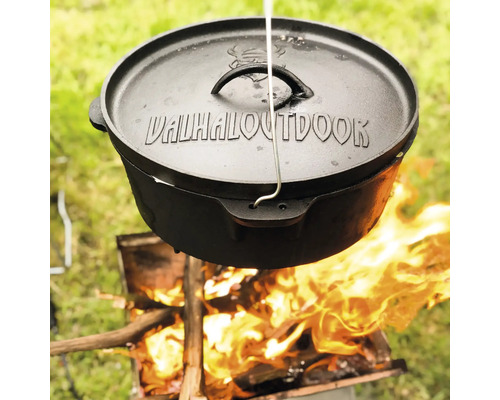 Gietijzeren Dutch Oven met deksel, hangend boven open vuur.