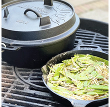 Gietijzeren Dutch Oven met deksel en groentepan op een grillrooster