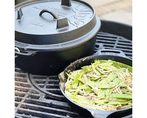 Gietijzeren Dutch Oven met deksel en groentepan op een grillrooster