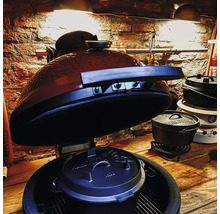 Keramische barbecue met Dutch Oven en kookpannen op houten tafel
