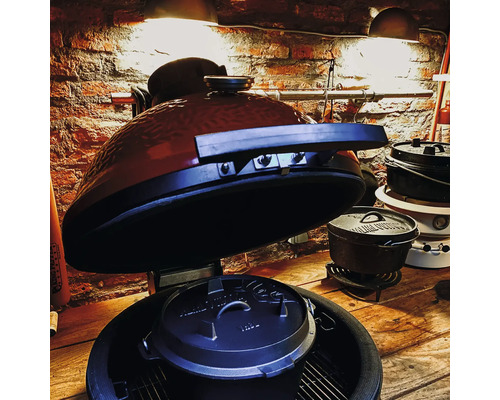 Keramische barbecue met Dutch Oven en kookpannen op houten tafel