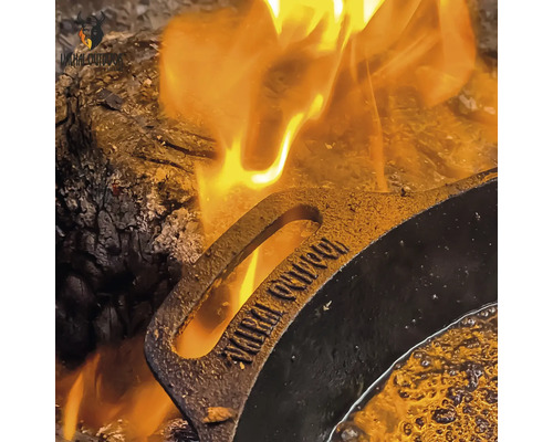 Een gietijzeren pan op een kampvuur.