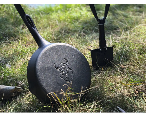 Gietijzeren pan met Vikingmotief en inklapbare schop in het gras