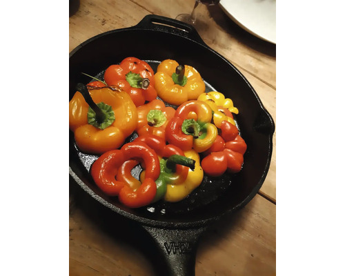 Meerkleurige paprika''s in een zwarte braadpan.