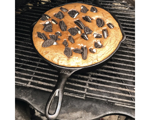 Gietijzeren koekenpan met chocoladetaart op een grill