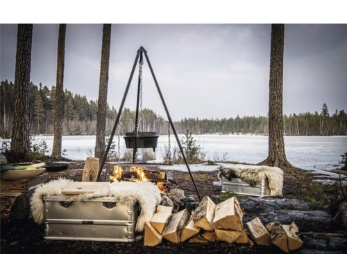 Scene met driepoot, ketel en brandhout bij een kampvuur in de natuur