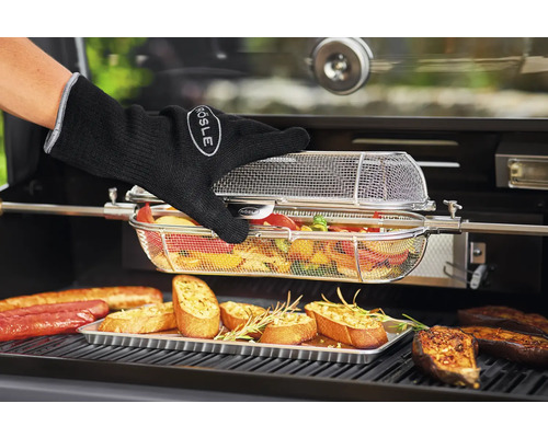 Grillscène met gegrild voedsel, grillhandschoen en groentemand aan het braadspit