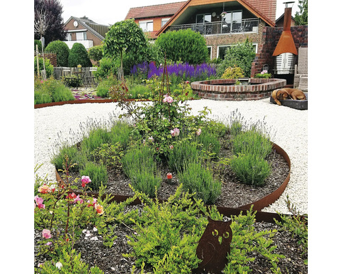 Aangelegde tuin met planten, grindpaden en decoraties.