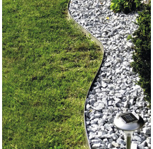 Tuinbeeld met gazon, grindpad, metalen rand en solarlamp