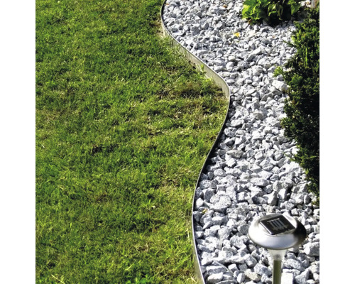 Tuinbeeld met gazon, grindpad, metalen rand en solarlamp