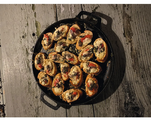 Bruschetta op een gietijzeren plaat op een houten tafel