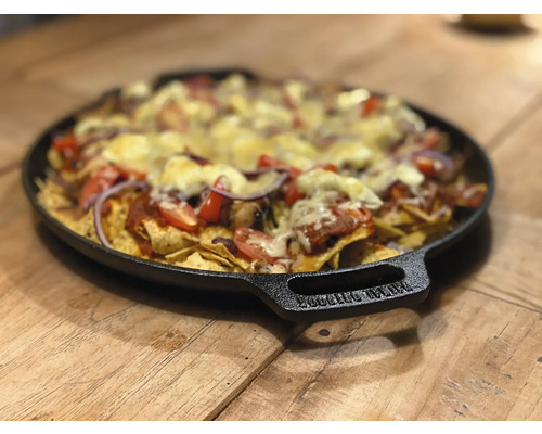 Nachos met kaas, tomaten en uien op een zwart bord