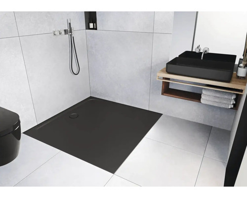 Moderne badkamer met vlakke, vierkante douchebak, wastafel en toilet.