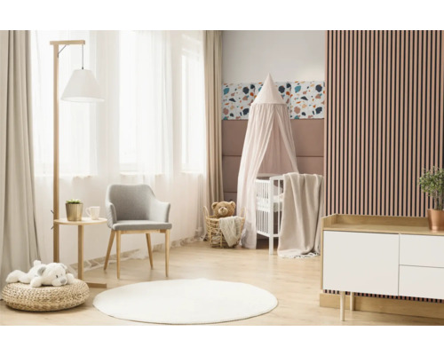 Lichte kinderkamer met babybed, stoel, commode en decoratieve elementen.