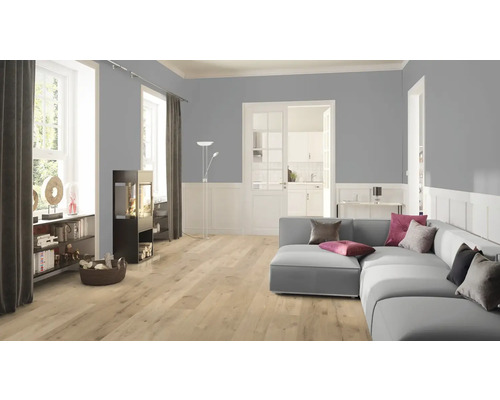 Woonkamer met bank, kachel en lichte laminaatvloer.