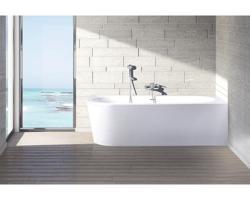 Moderne badkamer met vrijstaand bad, kraan en raam met uitzicht op zee.