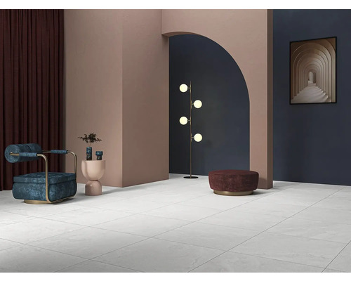 Lichte ruimte met tegelvloer, fauteuil, lamp en decoratie