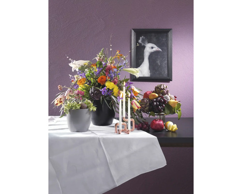 Feestelijk gedekte tafel met bloemstukken, kaarsen en fruit voor een afbeelding van een witte pauw