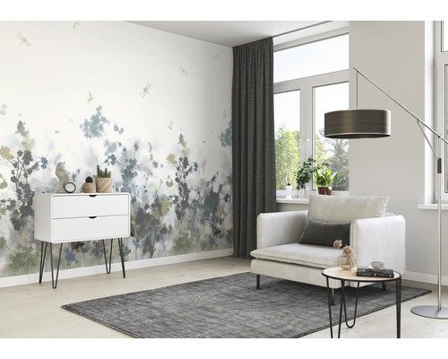 Woonkamer met patroonbehang, fauteuil en ladekast