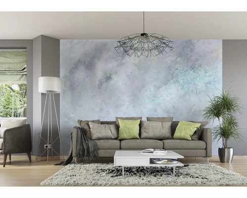 Woonkamer met bank, salontafel, vloerlamp, kamerplant en behang met patroon