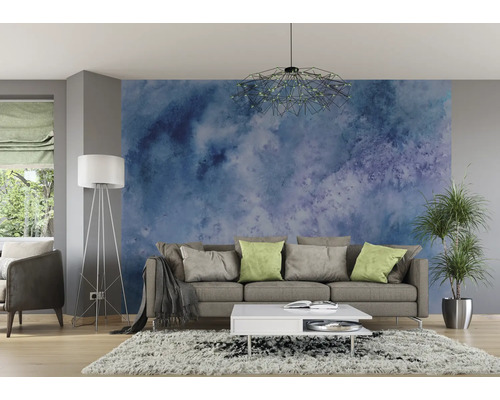 Woonkamer met bank, salontafel, vloerlamp en behang met motief