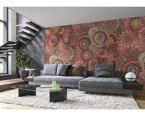 Woonkamer met grijze bank, glazen tafel en wandbehang met mandala patroon