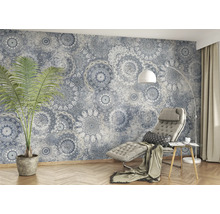 Woonkamer met patroonbehang, kamerplant en relaxstoel