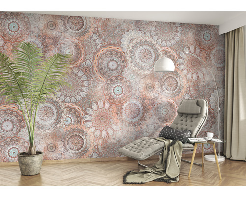 Woonkamer met patroonbehang, fauteuil, kamerplant en vloerlamp