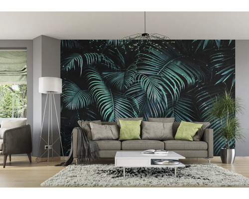 Woonkamer met fotobehang met tropische bladeren, bank, lamp en tapijt